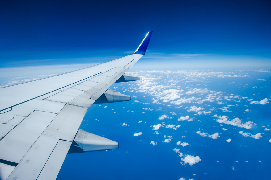 Avión sobrevolando la costa de Lagos, Nigeria, vista aérea de la ciudad y el mar, representando vuelos sin escalas desde Madrid